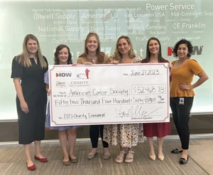 This is an image of DNOW employees holding a giant check with the amount of money they donated to the American Cancer Society.