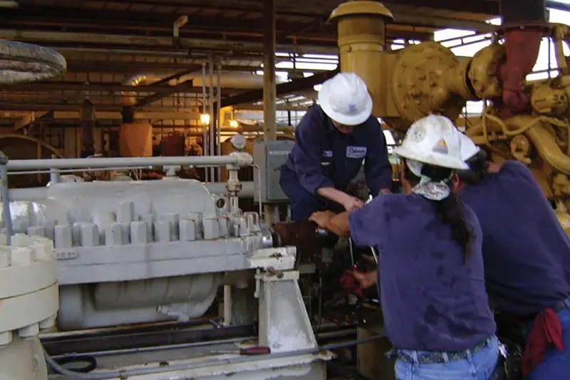 Image shows three technicians from Odessa Pumps performing alignment and startup services on a pump in the field to ensure customer compliance with industry standards